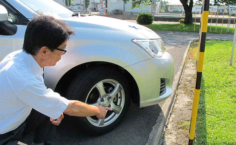 カーブをチェックする教習員