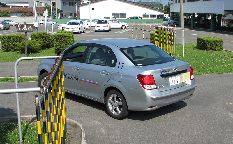 バック操作をする教習車